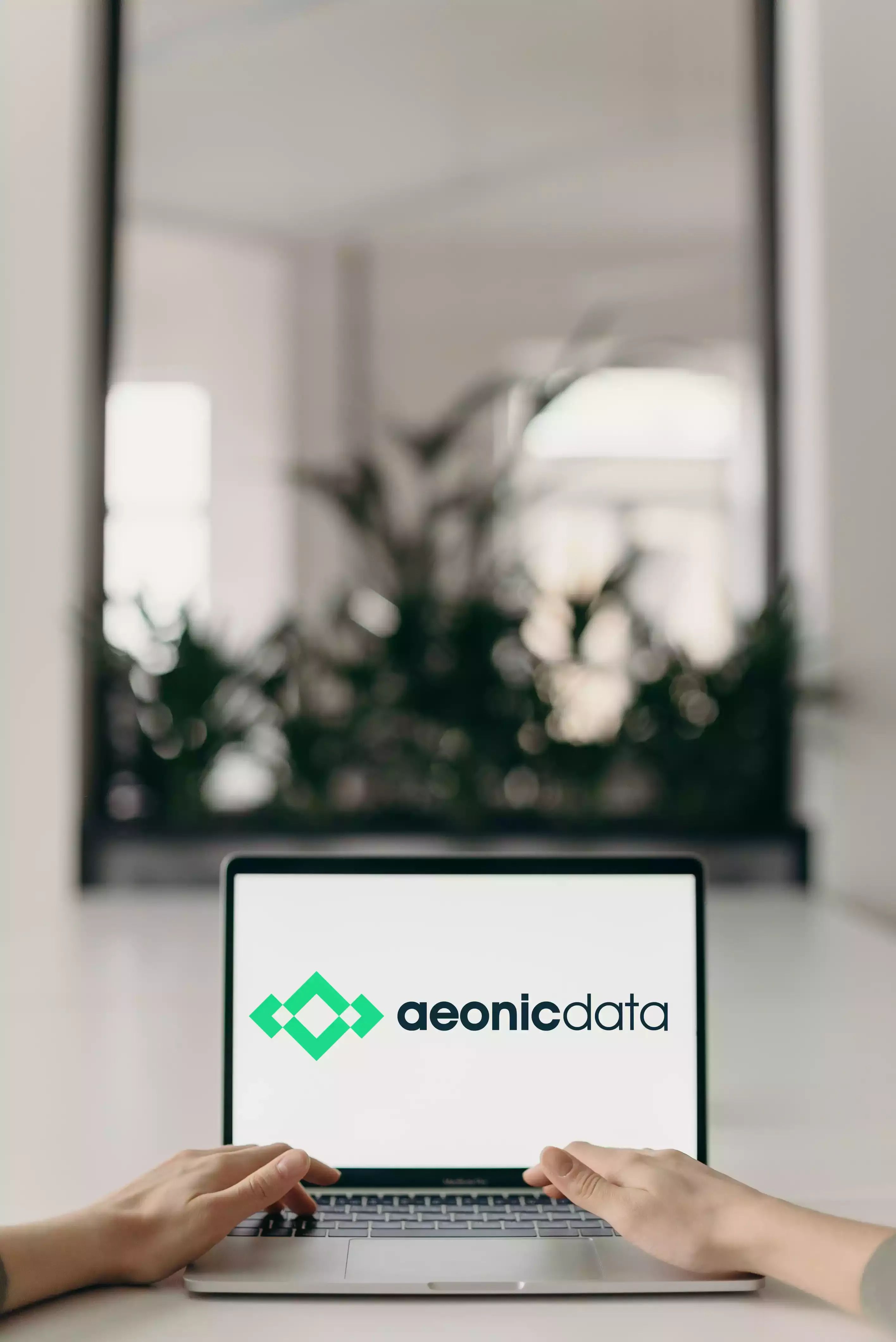 Ein Laptopbildschirm auf einem Schreibtisch, der das Aeonic Intelligence Logo zeigt.